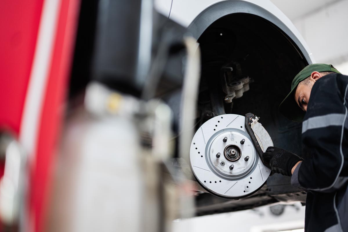 Mechanic inspecting car brake system in an auto repair shop