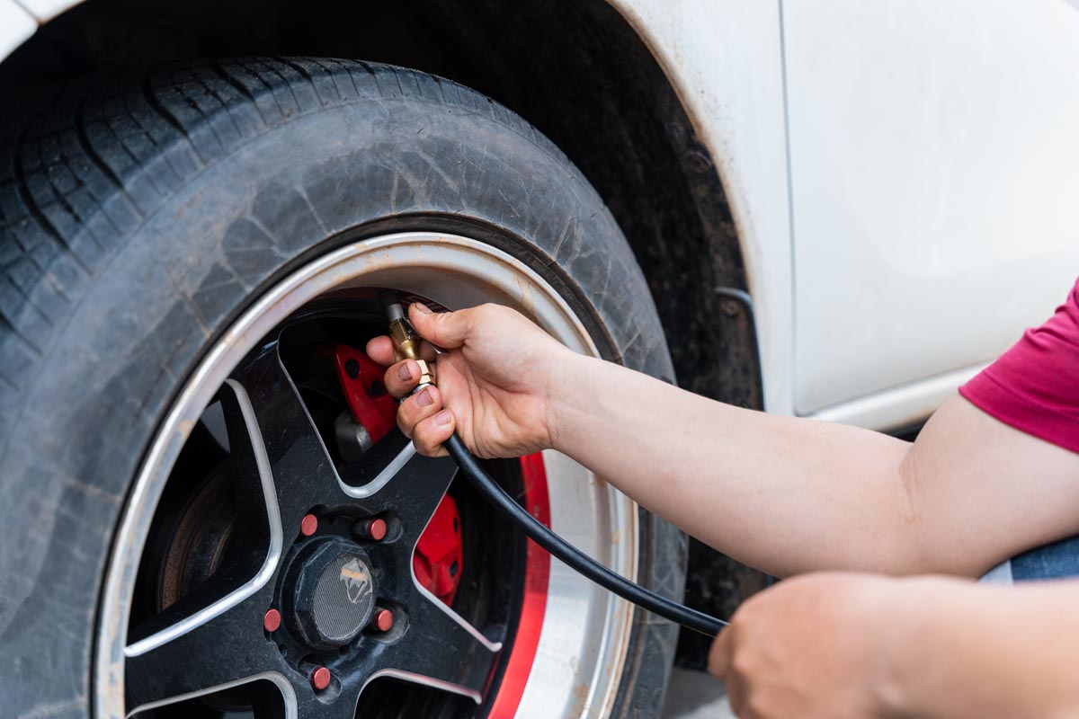 Close up of man filling air in the tires of his car